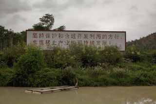 မြေရှားသတ္တုလုပ်ငန်းအား ရေရှည်တည်တံ့သည့် နည်းလမ်းဖြင့် ဖွံ့ဖြိုးတိုးတက်စေရေးအတွက် တိုက်တွန်းအားပေးသည့် အစိုးရဆိုင်းဘုတ်တစ်ခုအား တရုတ်နိုင်ငံ၊ ကျန်ရှီးပြည်နယ်၌ ၂၀၁၀ ခုနှစ်တွင် တွေ့မြင်ရပုံ။ အရင်းအမြစ်
